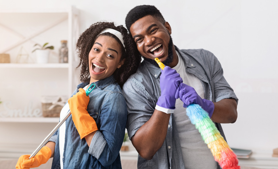 two people singing into cleaning supplies